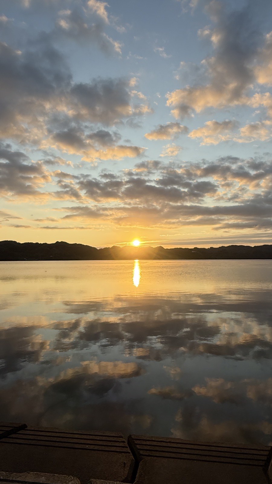 形上湾から見た元日の初日の出。雲のあいだから日がのぼり、水面にうつっている
