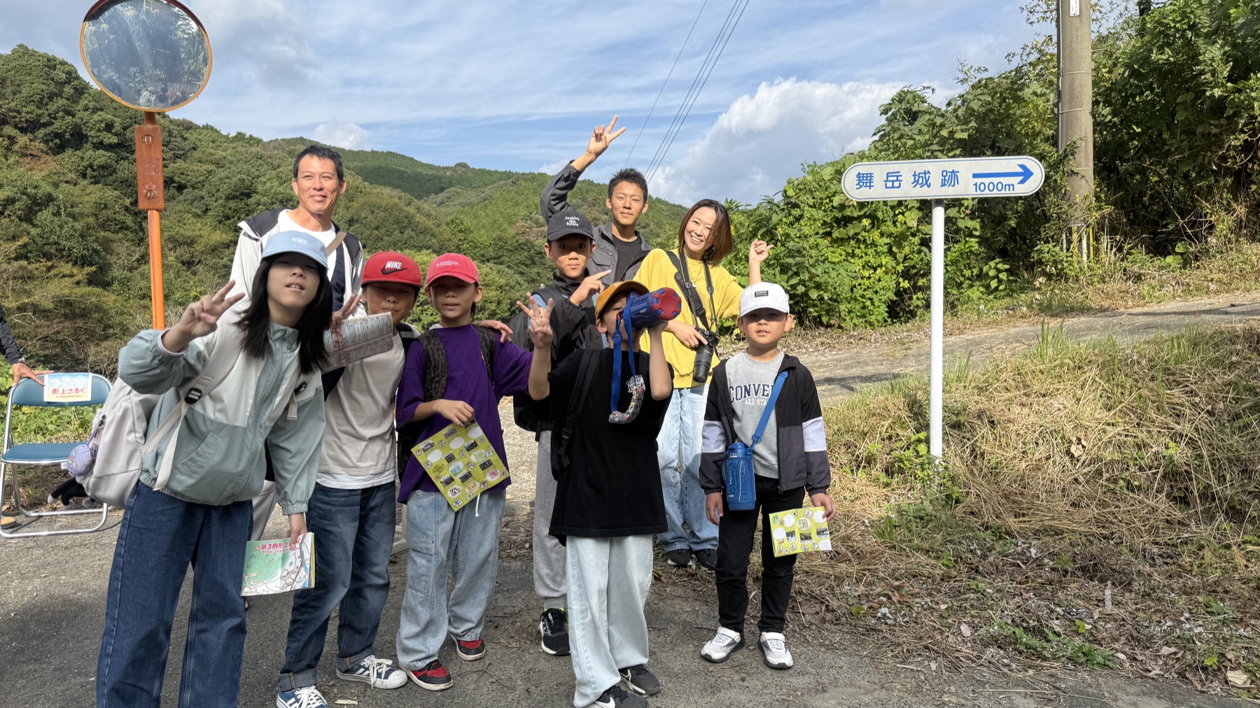 舞岳城跡へつづく道で、手をふってならぶ子どもたちと大人たち